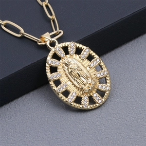 Macro view of gold virgin mary oval pendant with rhinestones on a paperclip chain