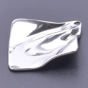 Macro detail of a silver wavy rectangular metal pendant with smooth mirror-like finish