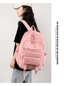 Zaino rosa in nylon impermeabile con scomparti multipli ed etichetta moda indossato da modella