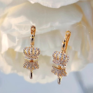 Detailed macro view of gold crown drop earrings with white pavé cubic zirconia
