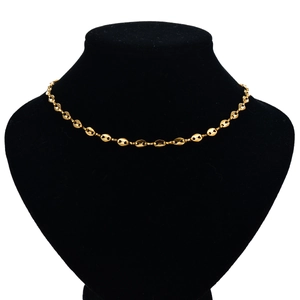 Macro view of gold stainless steel mariner link chain on a black neck display stand