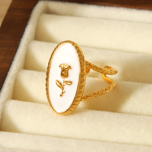 Detail of vintage gold rose ring with white enamel inlay in jewelry box