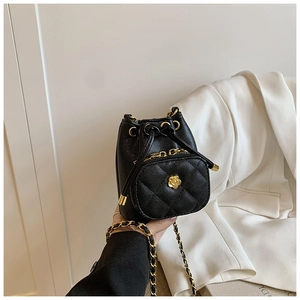 Detail of lychee pattern leather bucket bag with camellia flower and gold chain strap