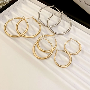 Close-up of assorted gold and silver hoop earrings in various sizes on a white display