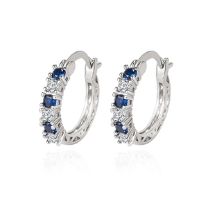 Silver huggie earrings with alternating blue and white crystals and geometric cutout sides
