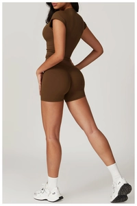 Detail view of high-waist yoga shorts with peach-lift stitching in dark brown earthy tone