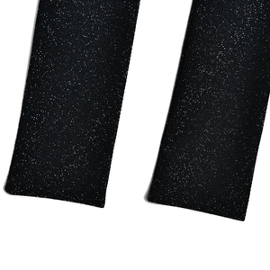 Detailed macro view of black sequined fabric showing shiny metallic glitter textures