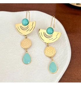 Detail of gold earrings featuring turquoise beads, hammered texture, and enamel pendants