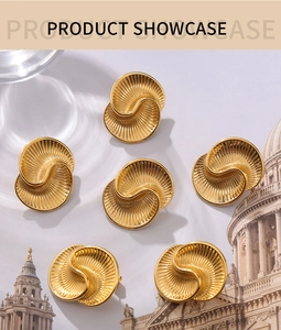 Detailed view of golden teardrop earrings with elegant spiral textures and embossed patterns