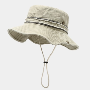 Detailed view of beige sun hat with wide brim, frayed trim ribbon and adjustable chin cord
