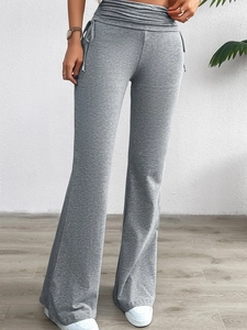 Gros plan sur un pantalon évasé gris à taille haute avec cordon de serrage et plis