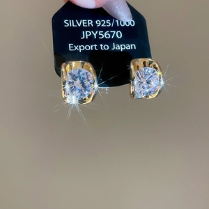 Macro shot of sparkling 18k gold plated 925 silver stud earrings with zircon stones