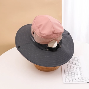 Detail view of pink sun hat with breathable mesh and adjustable buckle on a wooden stand