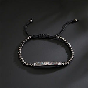 Detailed view of copper woven bracelet with gunmetal beads and colorful zircon bar