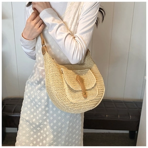 Detail of hand-woven beige hobo bag with unique front flap pocket and adjustable strap