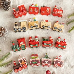 Detail of four miniature wooden Christmas trains with snow, pine cones and red berries