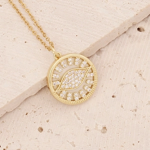 Macro shot of 18K gold eye pendant with cubic zirconia and white mother of pearl inlay