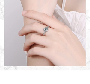 Close-up of a large round cubic zirconia ring with a paved band on a model's hand