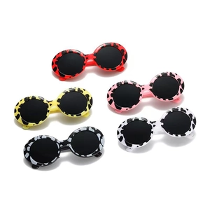 Round cow print sunglasses for dogs and cats in red, yellow, pink, white, and black