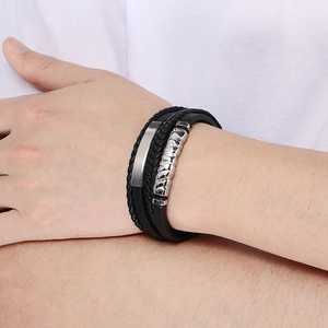 Detail of men's multi-layer woven leather bracelet with silver metal clasp on wrist