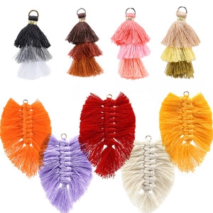 Detailed close-up of colorful three-layer tassels and bohemian woven leaf pendants