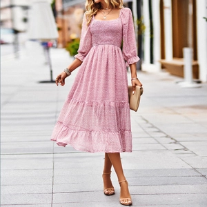 Elegant pink floral midi dress featuring a square neck and tiered skirt on city street