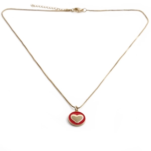Dettaglio macro della collana placcata oro con ciondolo tondo in smalto rosso e cuore d'oro