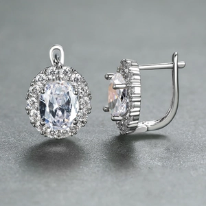 Macro shot of silver oval halo earrings with clear crystals and U-lever back closure