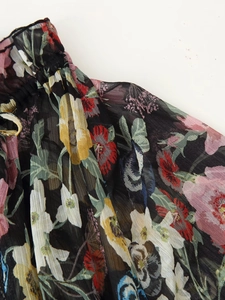 Close-up of floral print chiffon midi dress showing ruffled neckline and light fabric