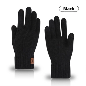 Dettaglio dei guanti invernali in maglia nera con logo cervo in pelle e polsini a coste