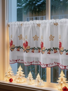 Detail of Christmas cafe curtain featuring festive candle embroidery and red scalloped edges