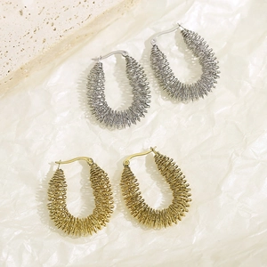 Vue détaillée de boucles d'oreilles en U avec texture spirale en or et argent