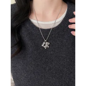 Silver horse necklace with Good Luck pendant on a grey sweater backdrop
