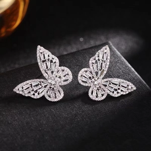 Macro shot of silver butterfly stud earrings with sparkling cubic zirconia on a jewelry box