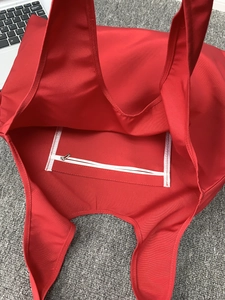 Detail view of the spacious red canvas tote bag showing the inner zipper pocket