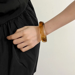 Amber translucent resin cuff bracelet with marble texture worn on wrist