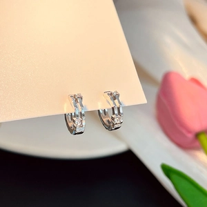 Détail de boucles d'oreilles créoles en argent avec double rangée de zircons sertis