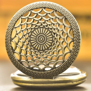Detailed close-up of a bronze vintage pocket watch with intricate hollow sunburst carving