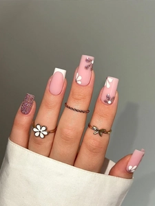 Macro detail of long coffin nails featuring pink base, French tips and 3D floral accents