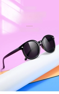 Gros plan de lunettes de soleil rondes pour enfants avec monture noire et rivets argentés