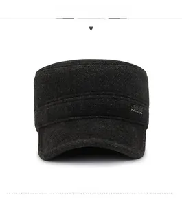 Detail view of dark grey wool blend flat cap featuring a metallic JEANS side plaque