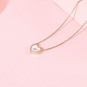 Détail du pendentif cœur en or rose avec nacre blanche et diamant en zircone