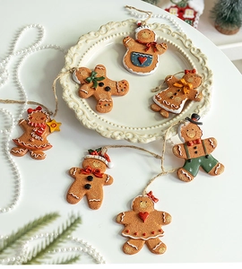 Set of six handcrafted resin gingerbread man ornaments displayed on a decorative white plate