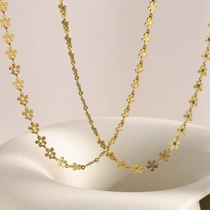 Detail of 18K gold plated necklace featuring white and turquoise enamel flower links