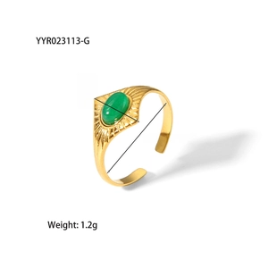 Détail d'une bague vintage en acier doré 18K avec pierre verte et gravure soleil radieuse