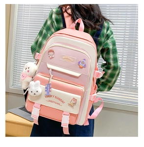 Pink and white school backpack with adjustable straps and plush charm shown on a model