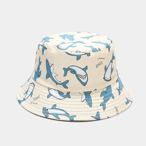 Detailed view of beige sun hat featuring blue shark patterns and artistic print fabric