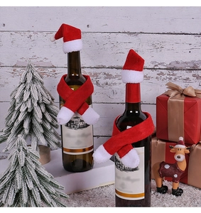 Close-up of mini Christmas hats and scarves set for wine bottle holiday table decoration