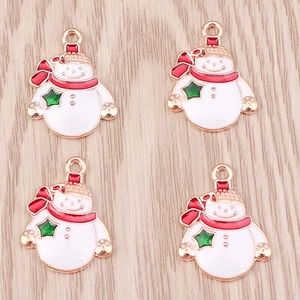 Macro shot of colorful enamel snowman pendants on a light wood grain surface