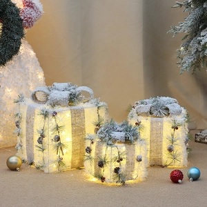 Three-piece glowing Christmas gift boxes with warm LED lights and snow texture decor